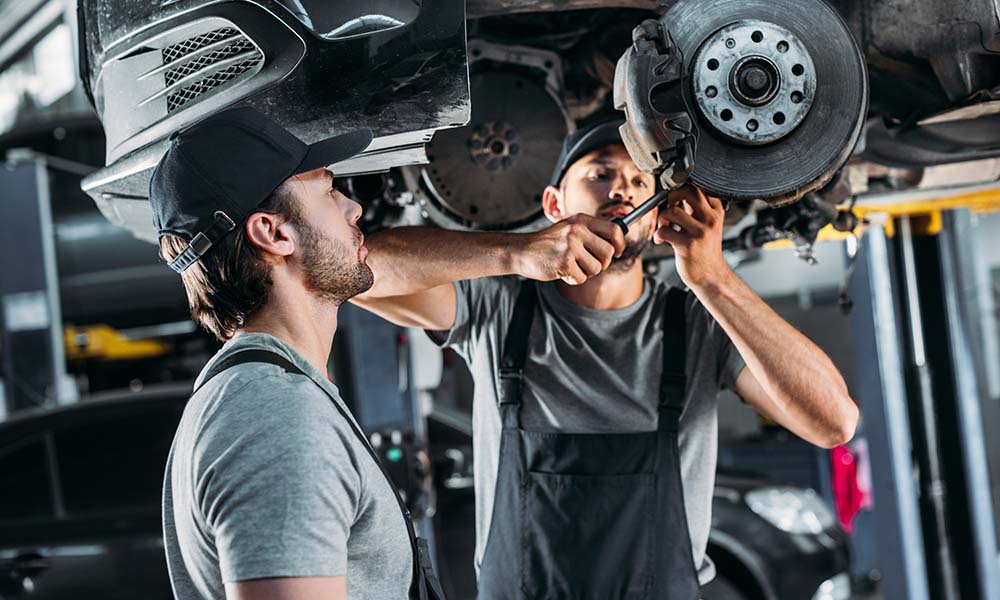 Mechanics working on repairing brakes
